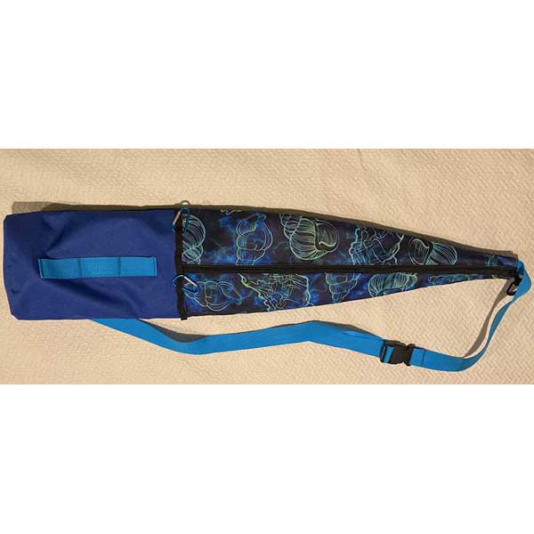 Blue and black bag with a patterned strap on a beige surface
