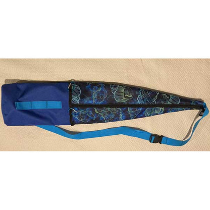 Blue and black bag with a patterned strap on a beige surface
