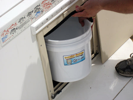 Person placing a white bucket with a label into a compartment on a vehicle.