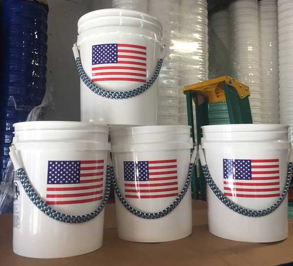 White buckets with American flag design stacked on a table.