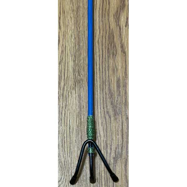 Blue and green object with a black base on a wooden surface