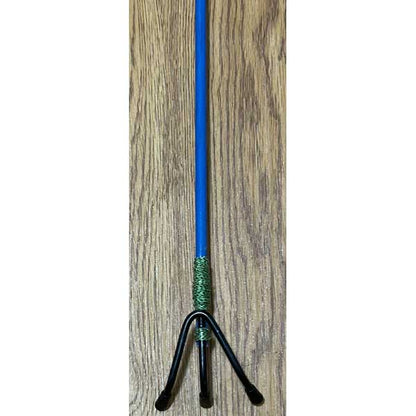 Blue and green object with a black base on a wooden surface