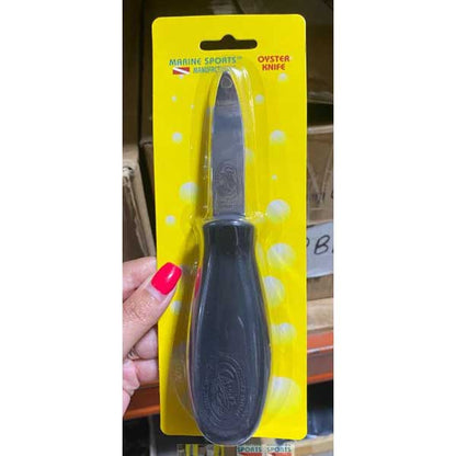 Oyster knife with black handle and clear blade on a yellow packaging, held by a hand.