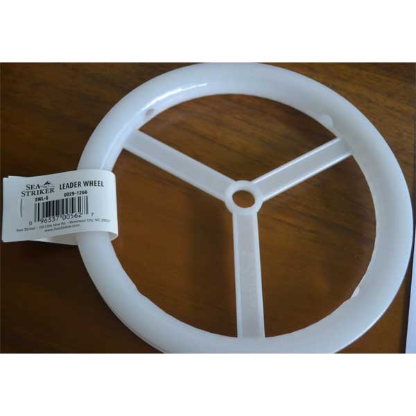 White fishing line wheel with a label on a wooden surface
