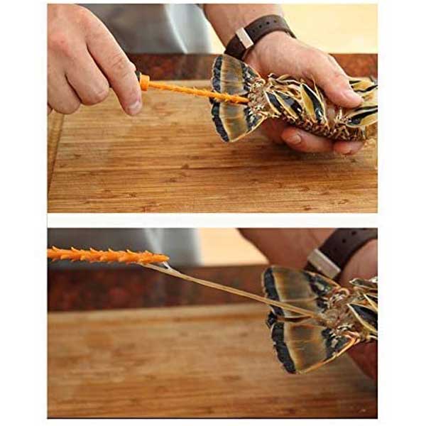 Person using a tool to extract intestines from a live lobster tail on a wooden surface.