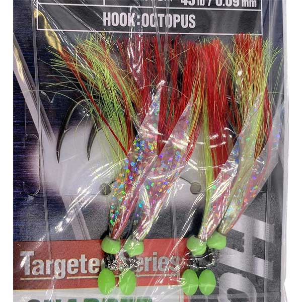 Fishing lure with colorful fibers and green base, packaging visible